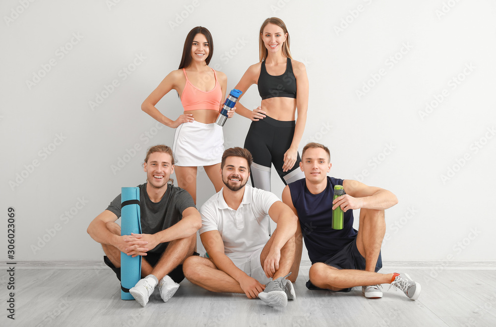 Group of sporty friends near white wall Group of sporty friends near white wall