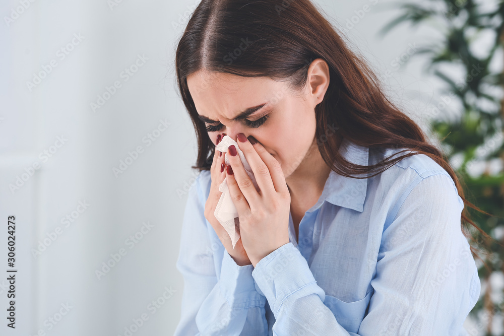 Woman ill with flu working in office Woman ill with flu working in office
