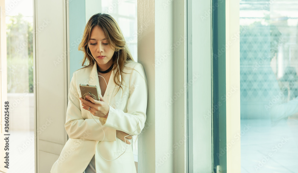 young business asian woman stand near window and uses digital smartphone young business asian woman stand near window and uses digital smartphone