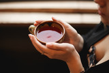 Red winter tea cup in female hands. Business woman warming her hands on a hot Cup of tea.