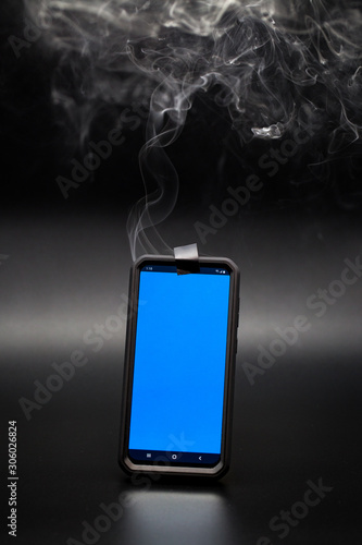 smoke coming from a smartphone with tape covering the phones camera