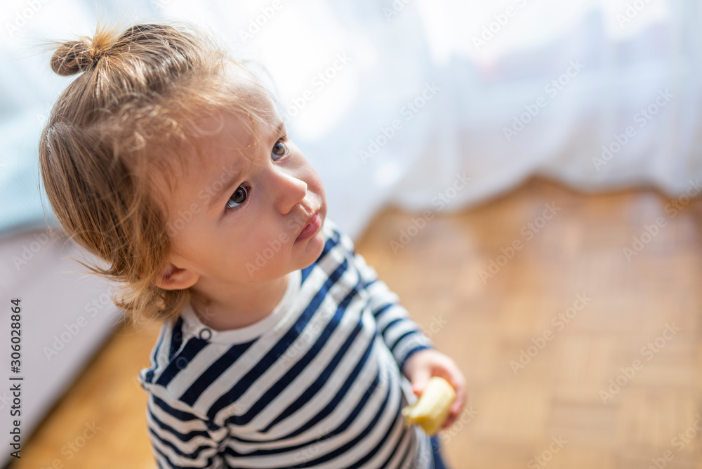 Young Boy Eating Banana At Home. Beautiful joyful child (little boy) eating healthy food (banana) at home. Happy kid enjoy eating fresh fruit. Healthy food for children concept. Young Boy Eating Banana At Home. Beautiful joyful child (little boy) eating healthy food (banana) at home. Happy kid enjoy eating fresh fruit. Healthy food for children concept.