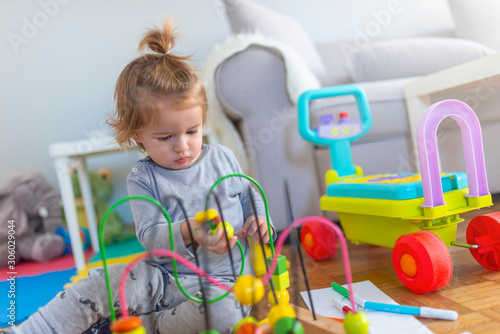 Baby boy playing with toy. Cute little boy is playing with toy. Early learning. Small toddler or a baby child playing. Kid baby boy sitting on floor at carpet and playing