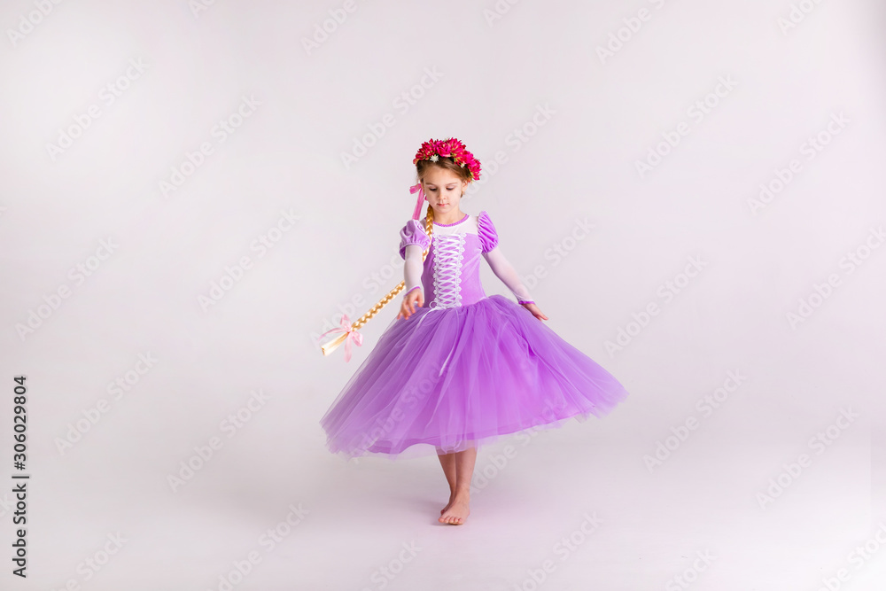 Little blonde girl wearing purple fairy princess dress on white background. Kids costume for new year party Little blonde girl wearing purple fairy princess dress on white background. Kids costume for new year party