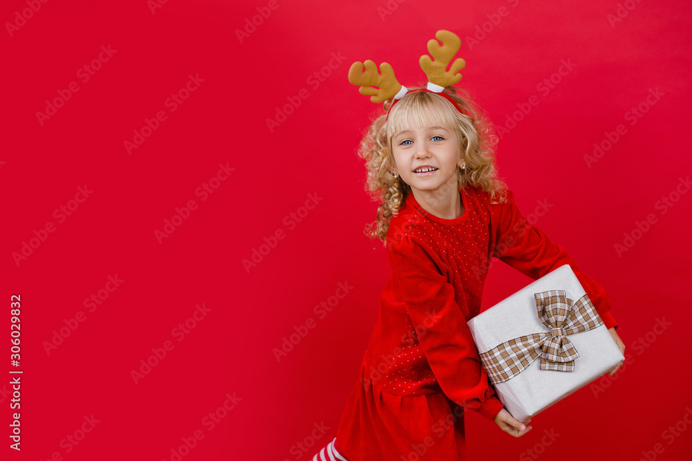 Happy excited girl child holding christmas gift box.