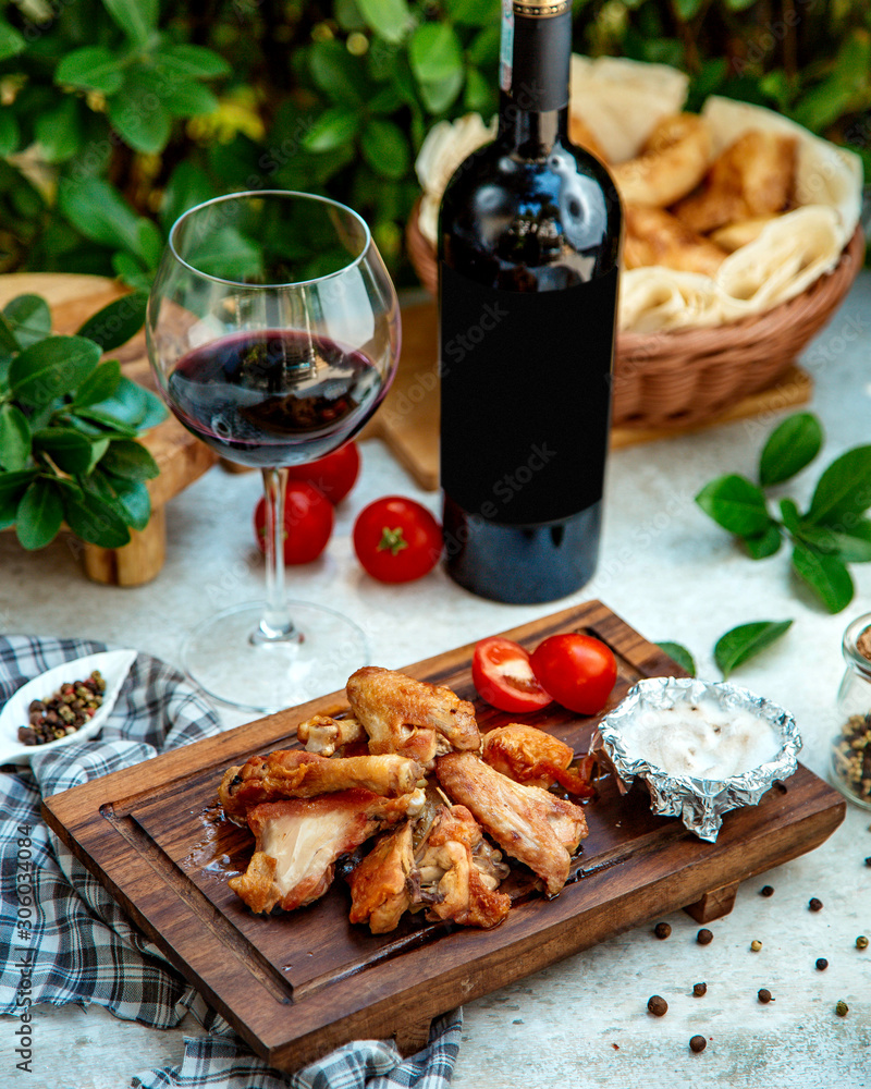 fried chicken on wooden board with red wine
