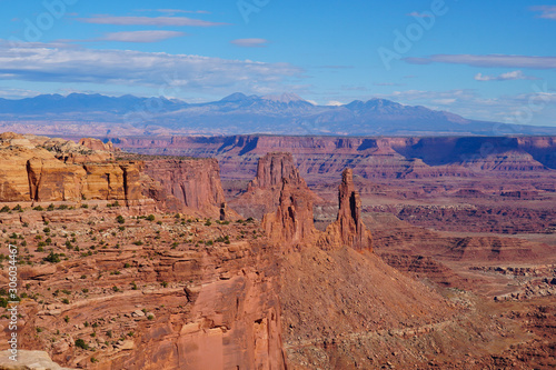 Looking into to the expansive red rock canyons of Canyonlands National Park with snow covered mountains in the background.