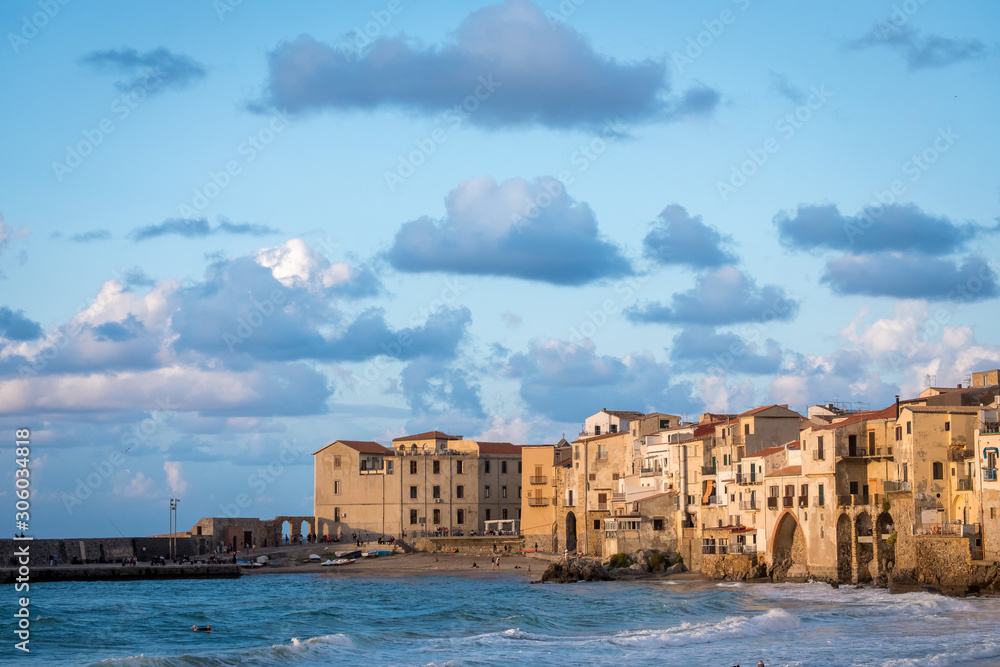 Seafront of Tyrrhenian Sea and Medieval houses of Sicilian coastal medieval city Cefalu in sunset