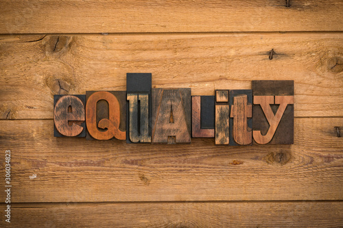 Equality, word written with vintage letterpress printing blocks on rustic wood background