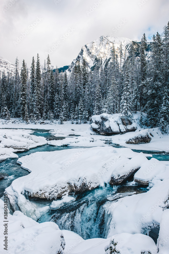 Fototapeta premium Partially frozen river with blue water in winter