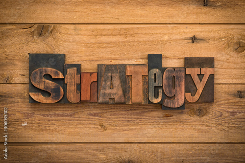 Strategy, word written with vintage letterpress printing blocks on rustic wood background