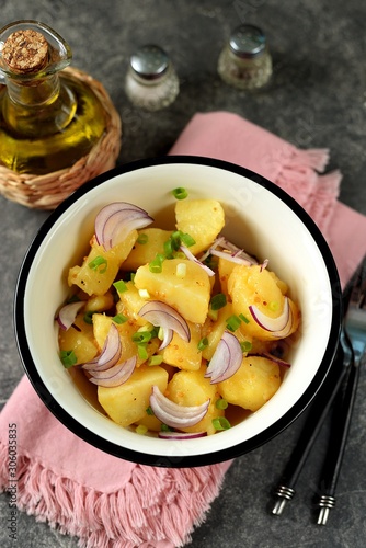 Traditional German potato salad with red, green onions and olive oil.