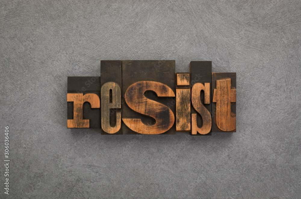 Fototapeta premium Resist, word written with vintage letterpress printing blocks on textured gray background