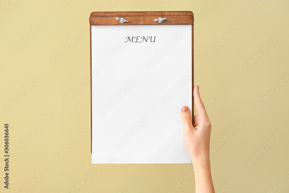 Female hand with blank menu on color background Female hand with blank menu on color background