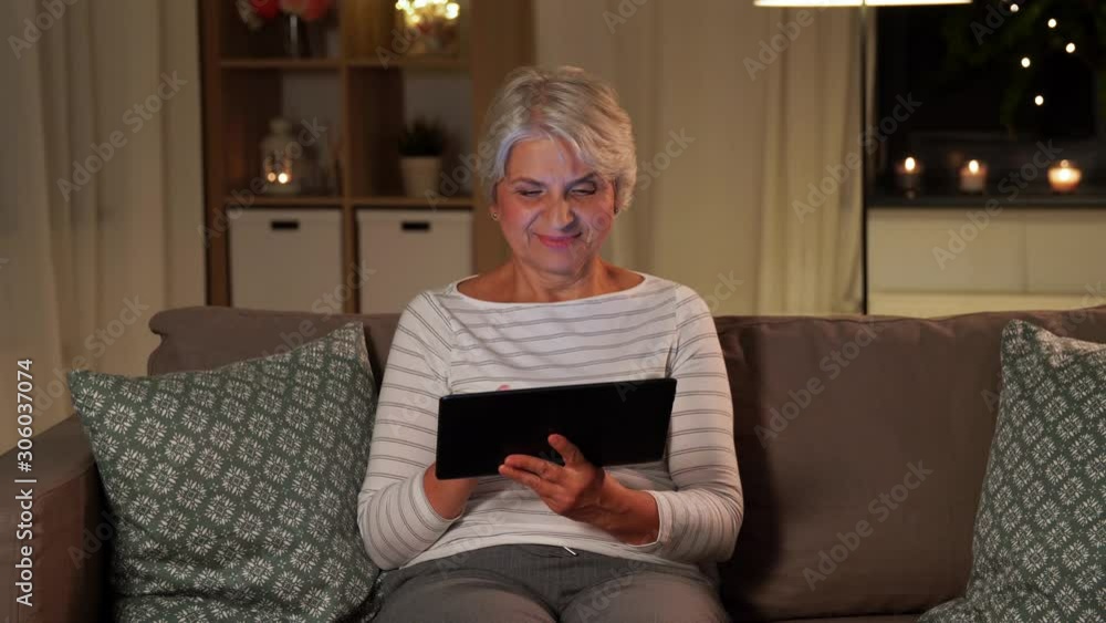 technology, old age and people concept - happy senior woman with tablet pc computer at home in evening technology, old age and people concept - happy senior woman with tablet pc computer at home in evening