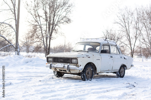 The car rides on a snowy highway. Difficult weather conditions.