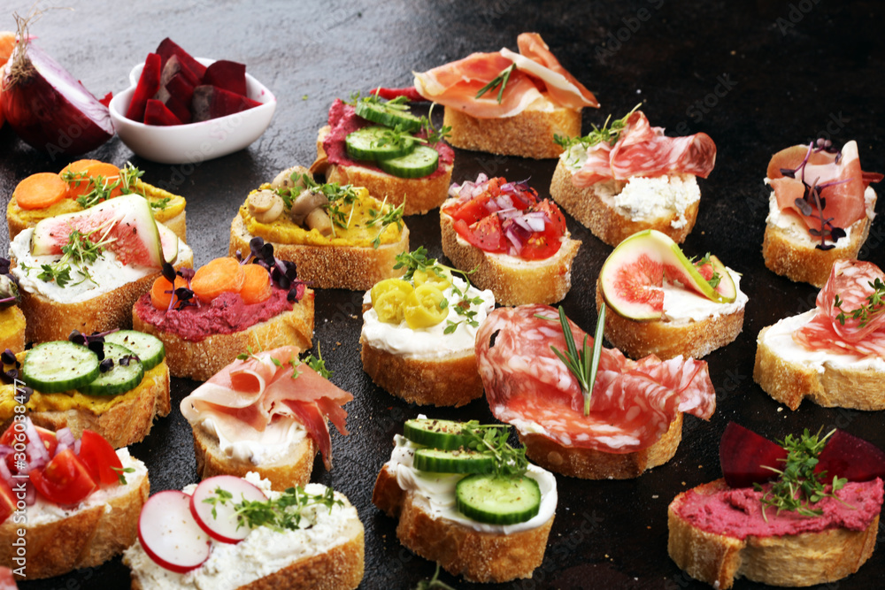 Assorted bruschetta with various toppings. Appetizing bruschetta or brie crostini. Variety of small sandwiches. Mix bruschetta on table Assorted bruschetta with various toppings. Appetizing bruschetta or brie crostini. Variety of small sandwiches. Mix bruschetta on table