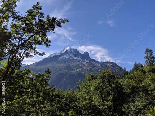 A scenic view of Alpine mountains on a beautiful sunny day. Rocky hills. Meadow