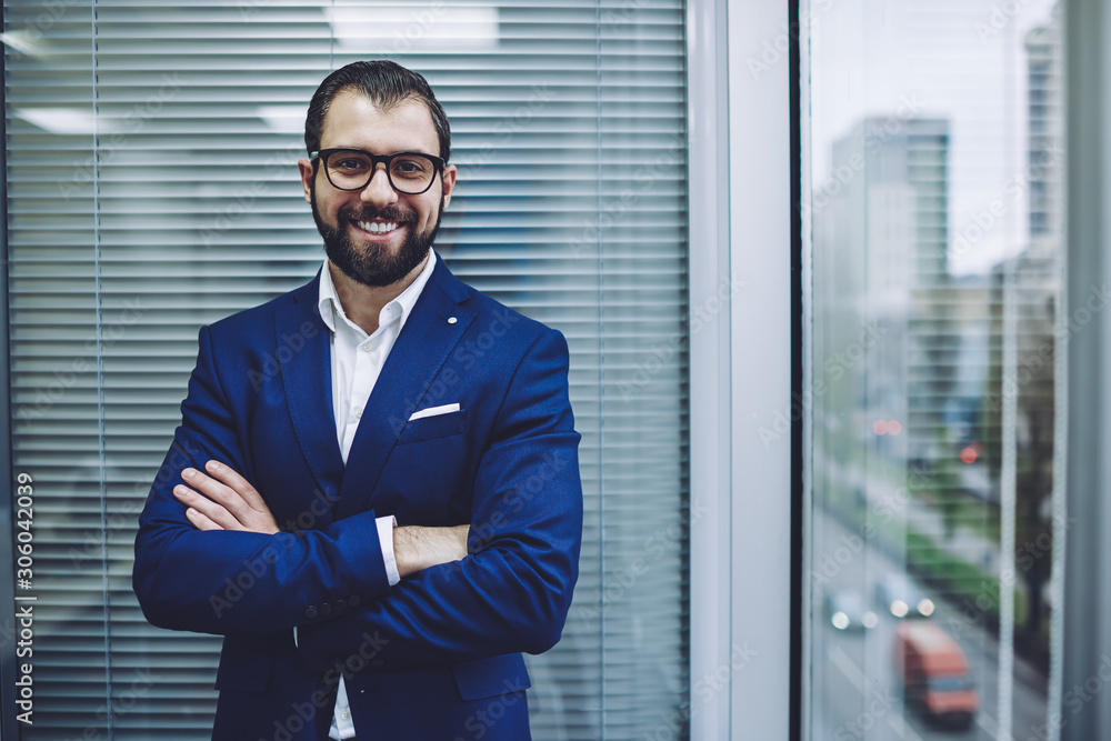 Confident cheerful male leader in stylish suit looking at camera and smiling during working time in office company, portrait of happy director in optical spectacles for provide eyes protection Confident cheerful male leader in stylish suit looking at camera and smiling during working time in office company, portrait of happy director in optical spectacles for provide eyes protection