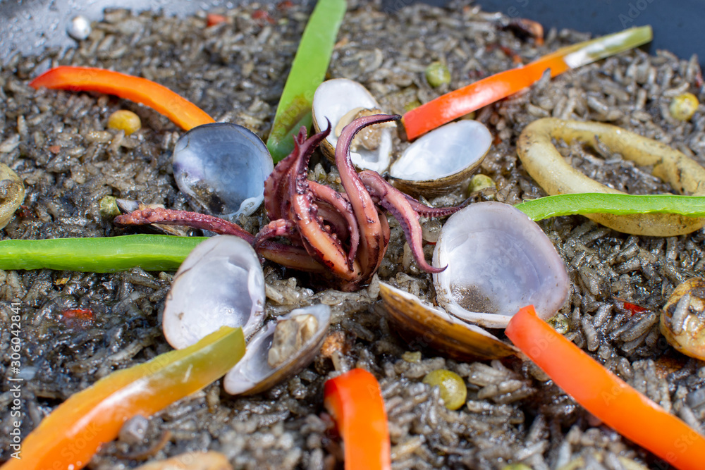 Traditional Spanish paella with different meat, seafood and vegetable ingredients Traditional Spanish paella with different meat, seafood and vegetable ingredients