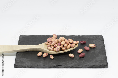 Bean pint or bean with wooden spoon on slate plate photo