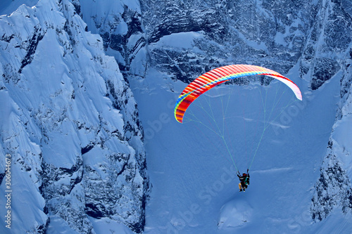 paraplane flying over snowy Caucasus mountains sunny blue sky photo