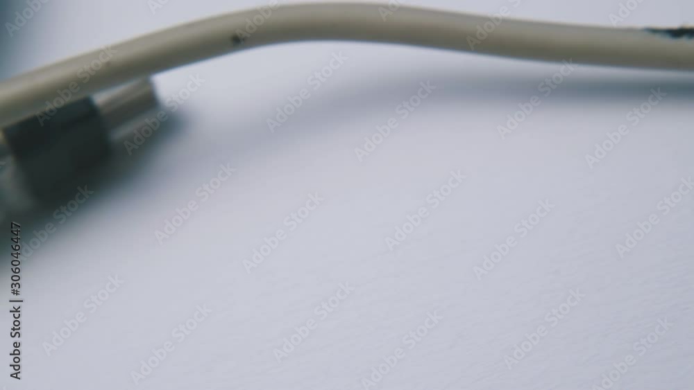 old grey usb cable with plugs for devices connection to computer on empty white surface extreme close view old grey usb cable with plugs for devices connection to computer on empty white surface extreme close view