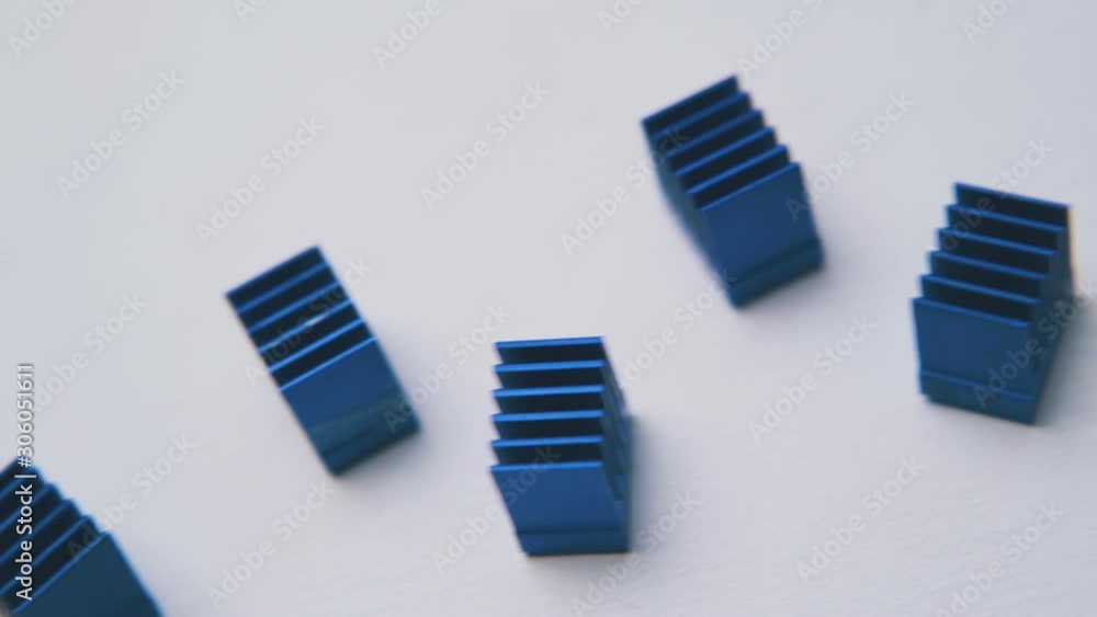 motion above small blue heatsinks for chips lying on clean white background extreme close view motion above small blue heatsinks for chips lying on clean white background extreme close view