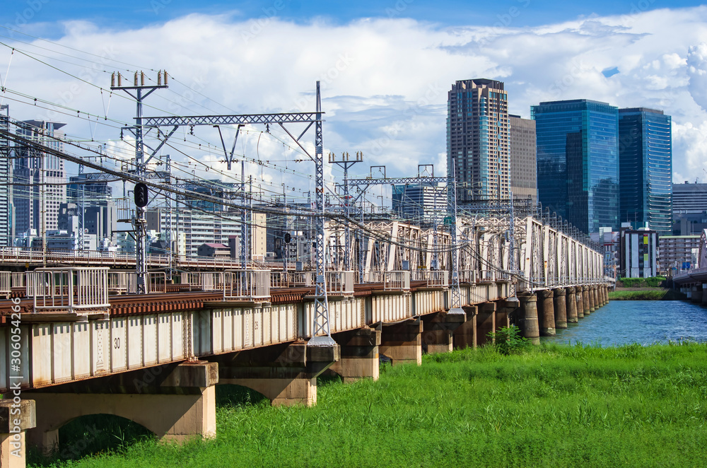 大阪・淀川に掛かる鉄橋と梅田のビル
