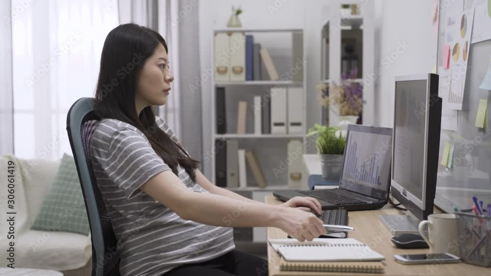 Midsection of pregnant businesswoman writing on notebook at desk in home office. elegant motherhood sitting at workplace typing on computer keyboard while one hand touching big belly. expecting baby. Midsection of pregnant businesswoman writing on notebook at desk in home office. elegant motherhood sitting at workplace typing on computer keyboard while one hand touching big belly. expecting baby.