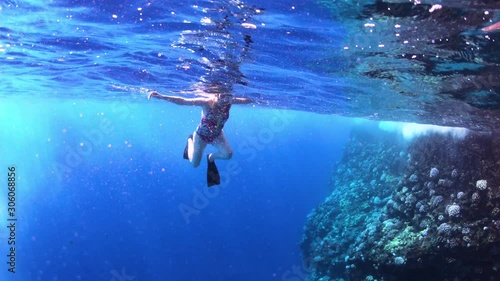 Under Water View Of Young Woman Swimming In Tropical Sea