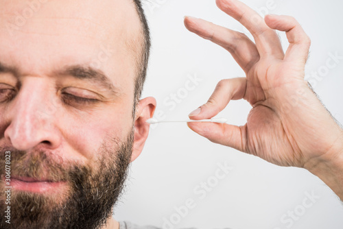 Man removing wax from ear using Q-tip