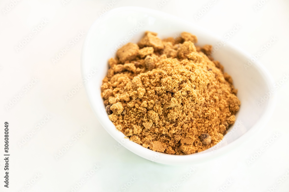 Unrefined cane sugar in white bowl. Evaporated cane juice is a healthy alternative to refined sugar. Unrefined cane sugar in white bowl. Evaporated cane juice is a healthy alternative to refined sugar.