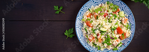 Traditional Lebanese Salad Tabbouleh. Couscous with parsley, tomato, cucumber, lemon and olive oil. Middle Eastern cuisine. Top view, banner