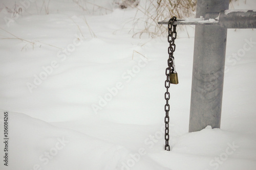 Open traffic barrier avalanche park gate in the snow with unlocked padlock