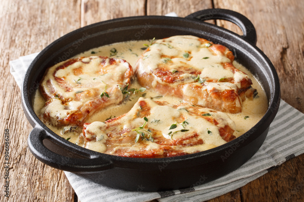 boneless pork chops served in creamy wine sauce with herbs close-up in a pan. horizontal boneless pork chops served in creamy wine sauce with herbs close-up in a pan. horizontal