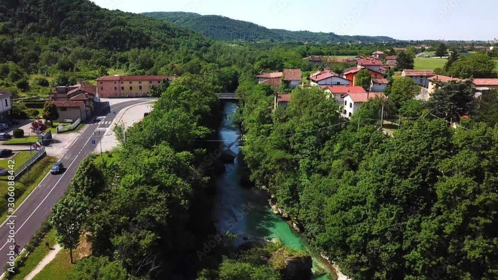 Forward drone shot above a river flowing near a country road, in Ponte San Quirino, Italy Forward drone shot above a river flowing near a country road, in Ponte San Quirino, Italy