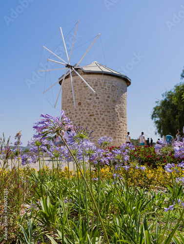 Windmill, flowers and blue sky. Alacati, Cesme, İzmir / Turkey-June 23,2019