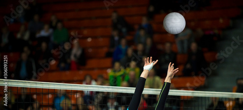 Girl Volleyball player and setter setting the ball for a spiker during a game. Team sport.