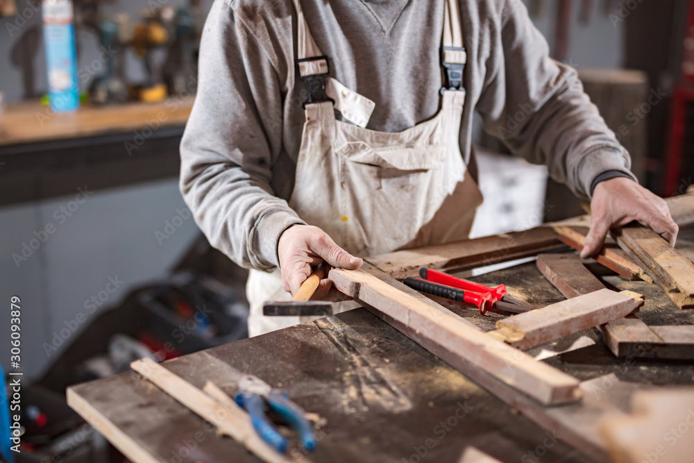 Carpenter working on a old wood in a retro vintage workshop. Carpenter working on a old wood in a retro vintage workshop.
