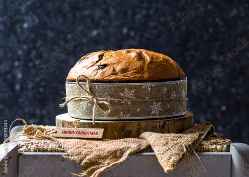 Panettone, typical christmas italian food, on rustic wooden background.