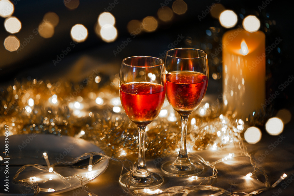 Celebration theme with two red wine glass on small gold light background Celebration theme with two red wine glass on small gold light background