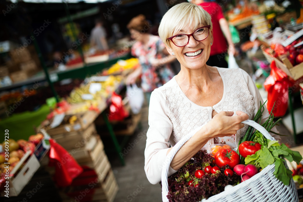 Picture of mature woman at marketplace buying vegetables Picture of mature woman at marketplace buying vegetables