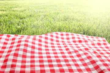 Picnic cloth on green grass background empty space.