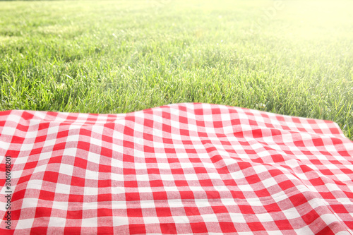 Picnic cloth on green grass background empty space.