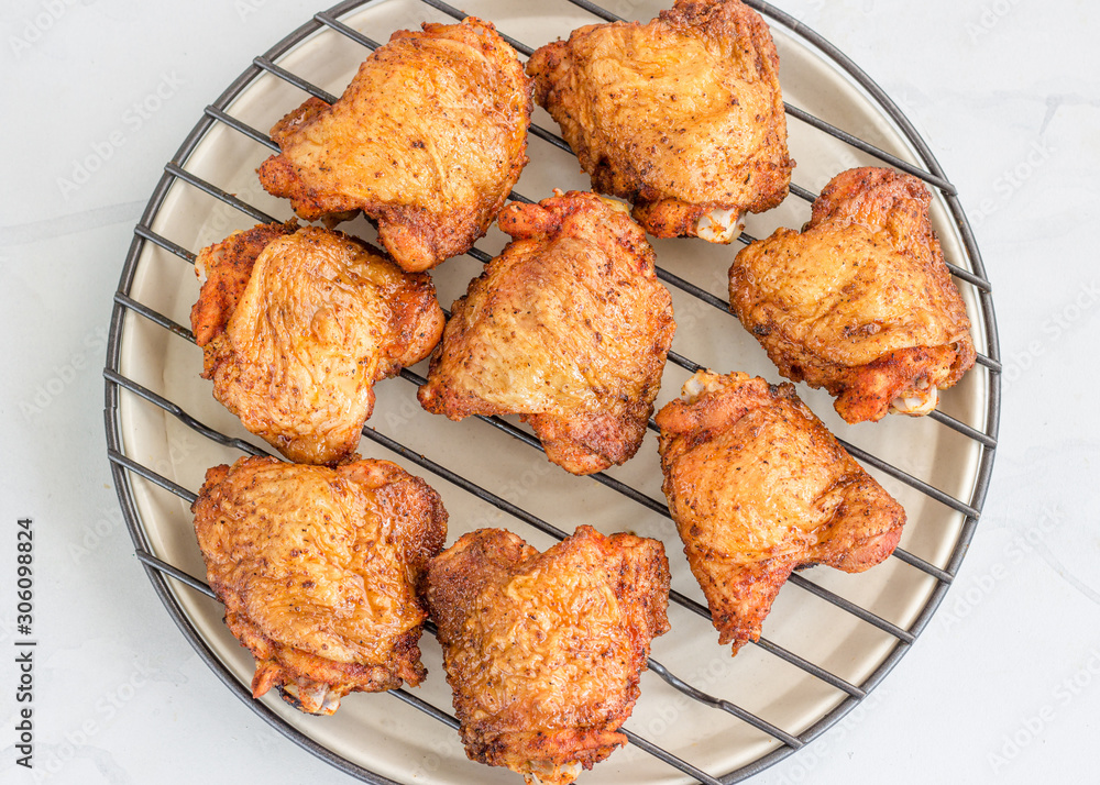 Crispy Oven Fried Chicken Thighs on a grill Rack on White Background, Top View Food Photography.. Crispy Oven Fried Chicken Thighs on a grill Rack on White Background, Top View Food Photography..