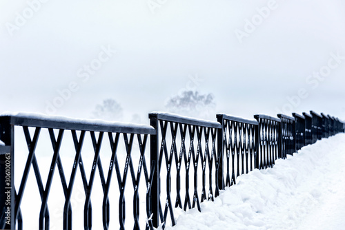 Fototapeta Naklejka Na Ścianę i Meble -  Steel fence along the embankment of the river during the fog in winter in severe frost