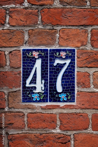 number 47 tile on brick wall