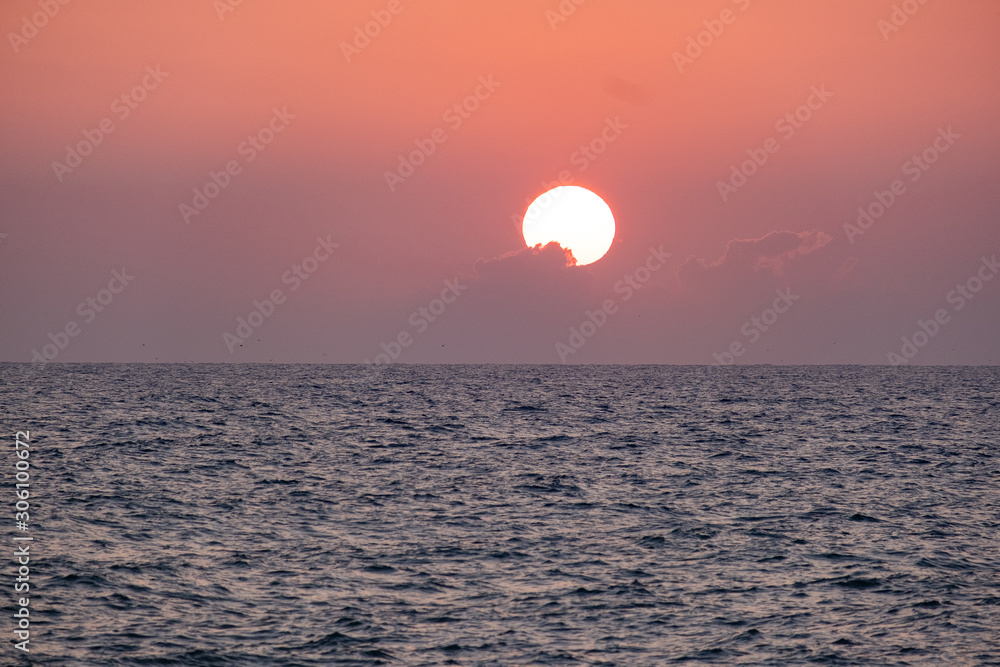 Sunset over the sea. Orange color of the sky