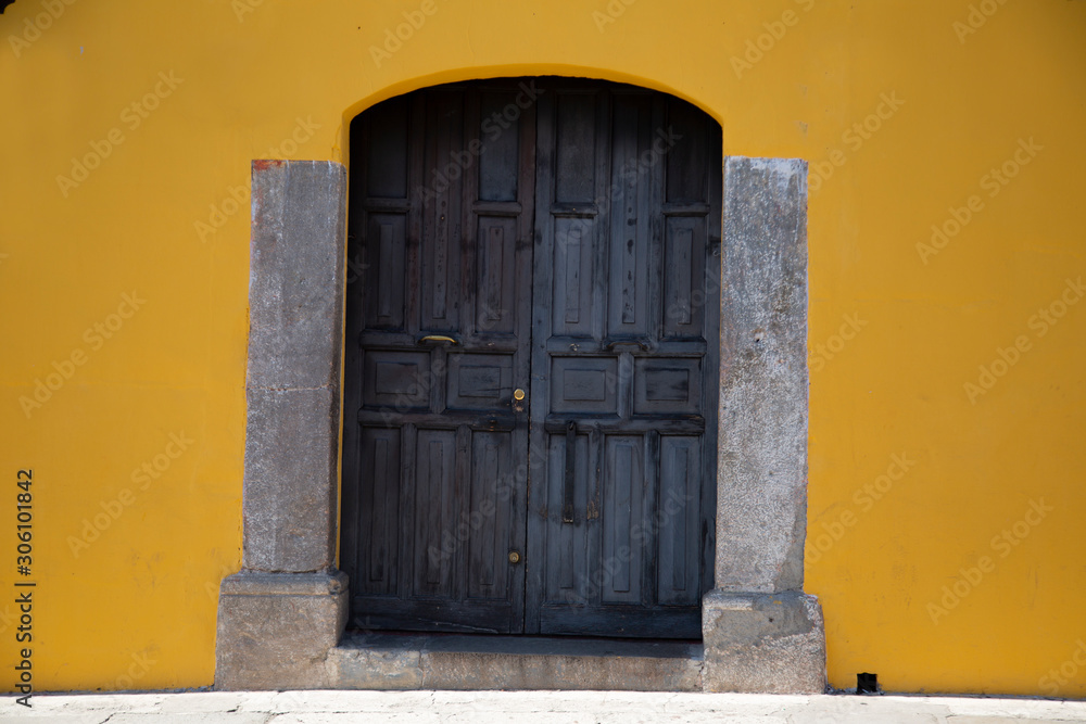 Old door in colonial city with yellow wall- Antigua Guatemala Old door in colonial city with yellow wall- Antigua Guatemala